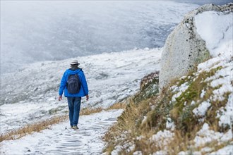 Australia, New South Wales, Woman hiking on snowy trail at Charlotte Pass in Kosciuszko National Park