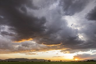 Usa, Idaho, Bellevue, Storm clouds over fields at sunset