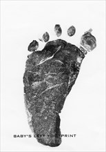 Footprint made with ink on paper of new born infant boy