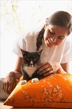 Smiling woman petting cat