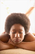 Close-up of woman with eyes closed receiving back massage