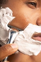Close-up of man shaving