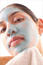 Close-up of woman removing blue facial mask