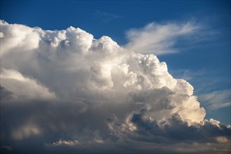 Dramatic formation of cumulus storm clouds against blue sky
