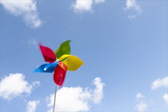 Colorful pinwheel blowing in wind against sky