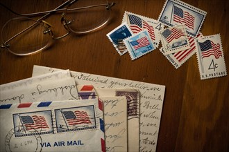 Letters with American flag postage stamps on table