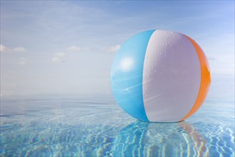 Beach ball floating on calm water surface