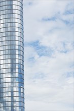 Tall modern building exterior and cloud covered sky