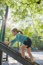 Girl climbing slide at playground