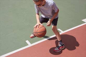 Boy dribbling basketball in park