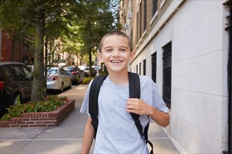 Portrait of smiling Boy wearing backpack in city