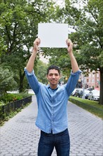 Portrait of man holding blank sign