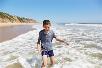 Smiling boy playing in sea waves