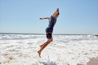 Boy jumping in sea waves