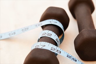 Close-up of dumbbells and measuring tape