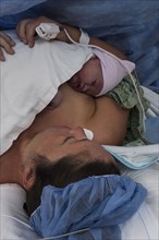Mother lying in hospital with newborn baby girl
