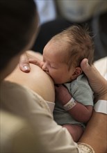 Mother breastfeeding newborn baby girl