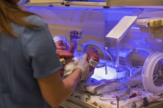 Nurse placing newborn baby girl