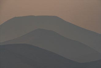 Silhouettes of layered mountains