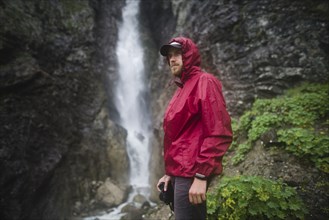 Hiker standing near waterfall