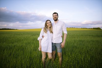 Portrait of couple standing in agricultural field