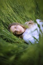 Young woman lying in grass