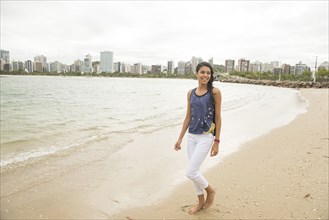 Smiling woman walking on urban beach