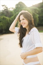 Smiling Caucasian woman standing on beach