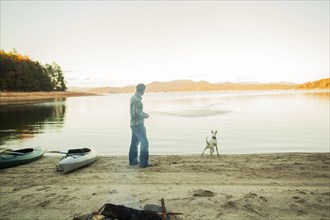 Man and dog playing in remote lake