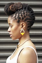 Profile of African American woman with braids near metal wall