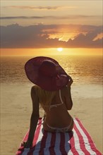 Caucasian woman admiring sunset on beach