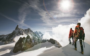Caucasian hikers standing on snowy mountain top