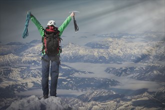 Caucasian hiker cheering on mountaintop