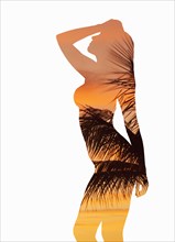 Silhouette of Caucasian woman with palm leaves and sunset