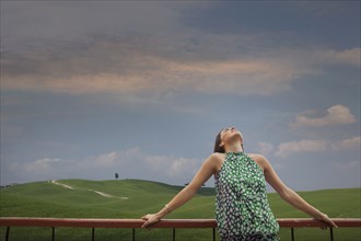 Caucasian woman admiring blue sky in rolling landscape