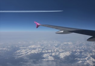 Airplanes flying in blue sky over Swiss Alps