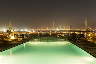 Swimming pool over cityscape at night