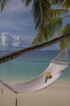 Sun hat in empty hammock on beach