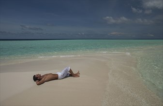 Caucasian man laying on beach