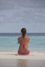 Caucasian woman sitting on beach