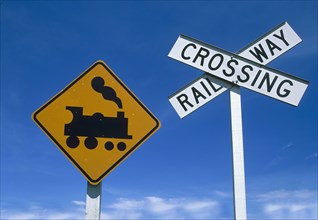 Low angle view of railway crossing signs