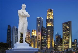 Statue and Singapore city skyline at night