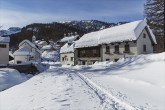 Path through snow to rural mountain village