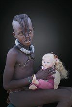 Black girl playing with baby doll