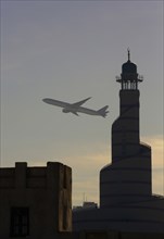 Airplane flying over Doha cityscape