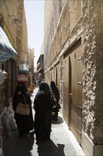 Women in hijab walking on Doha sidewalk