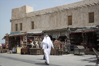 Man walking outside market on Doha sidewalk