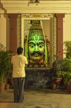 Man admiring statue in ornate temple
