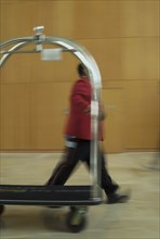 Blurred view of bellhop and luggage cart in hotel