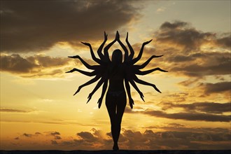 Caucasian woman with many arms under sunset sky
